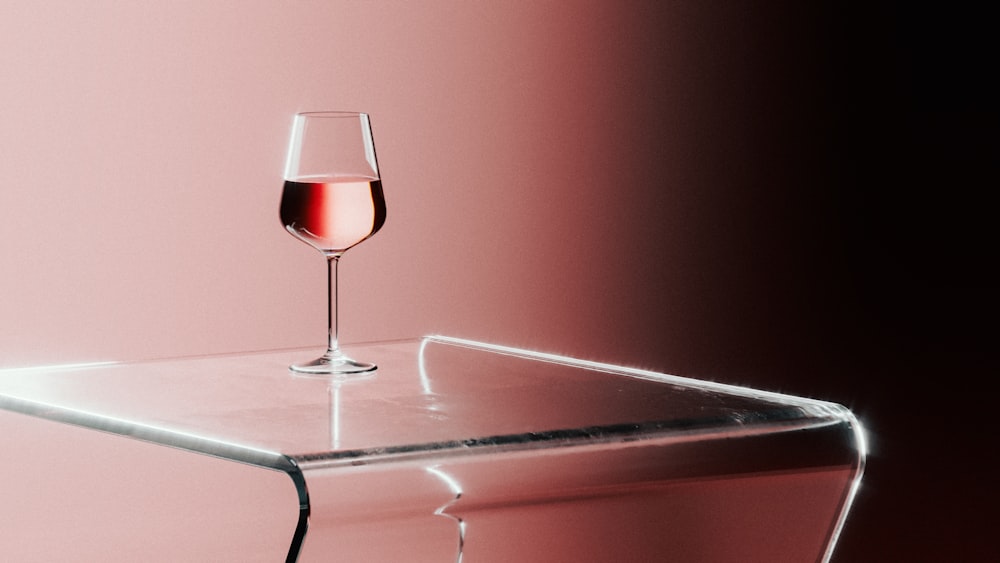 un bicchiere di vino seduto sopra un tavolo