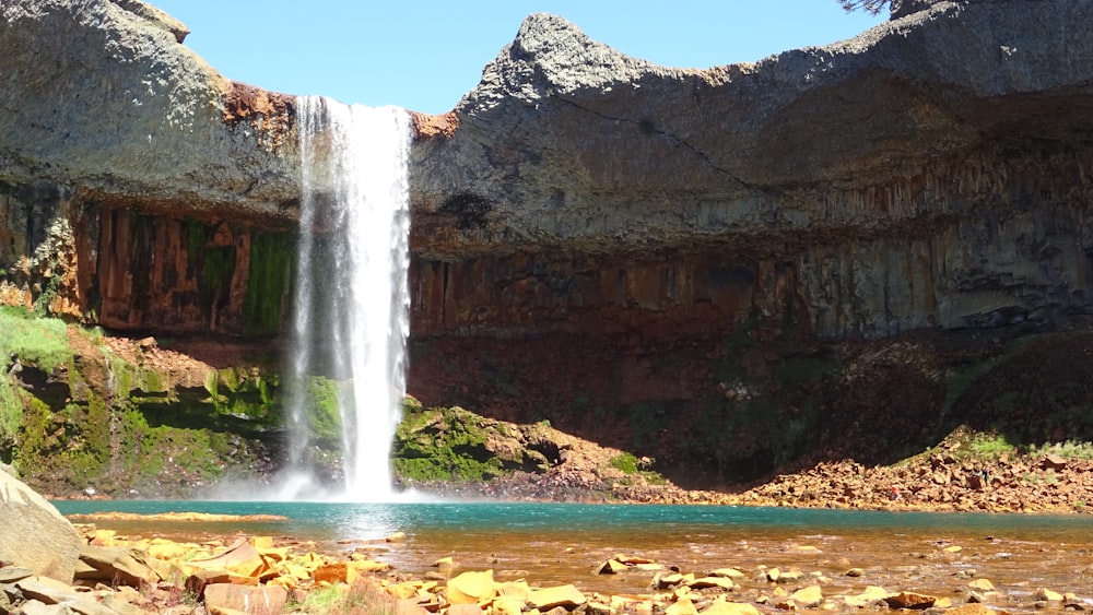 a large waterfall is in the middle of a lake