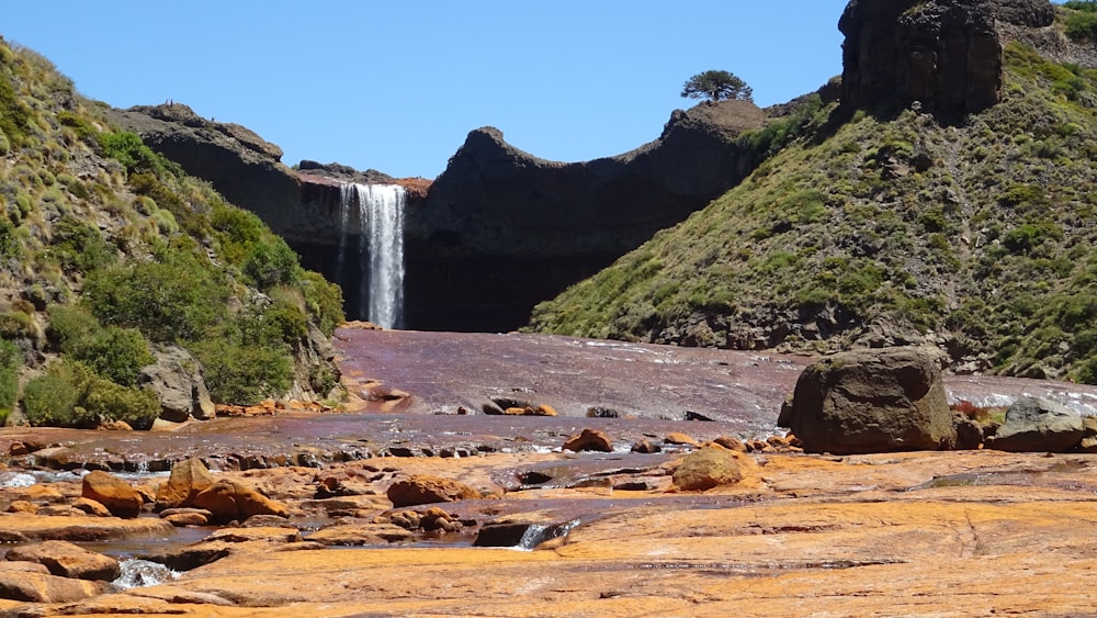 a small waterfall in the middle of a rocky area