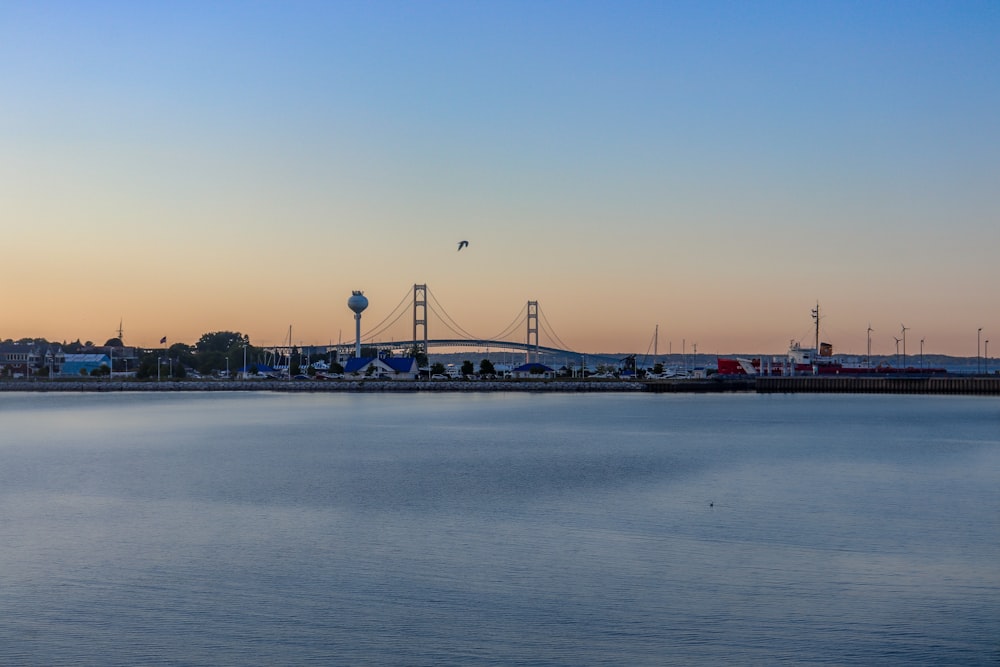 a large body of water with a bridge in the background