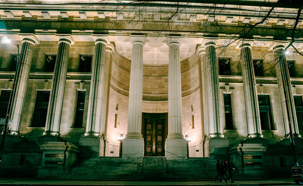 a large building with columns and lights at night