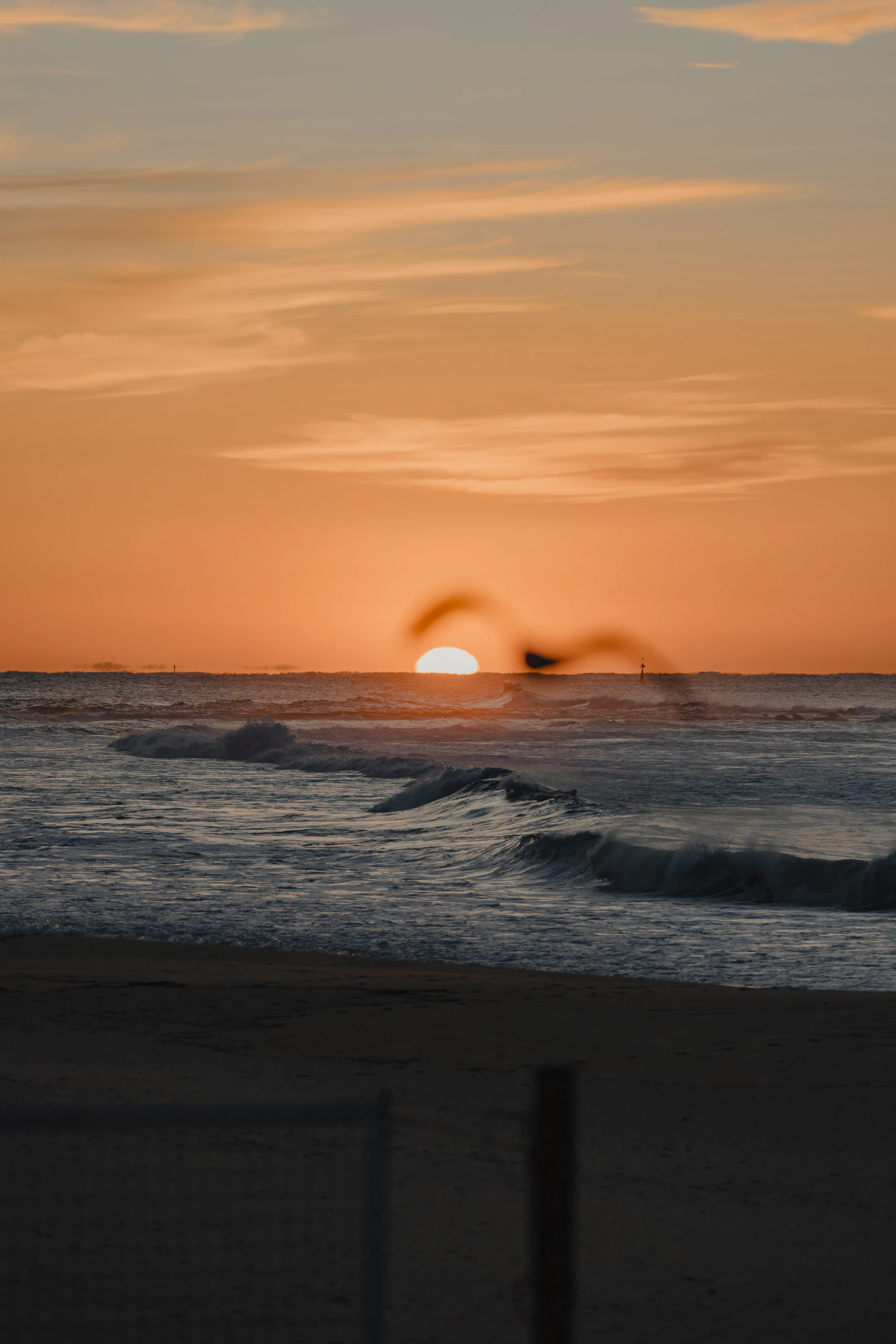 Ocean waves stretching toward a bright coastal horizon