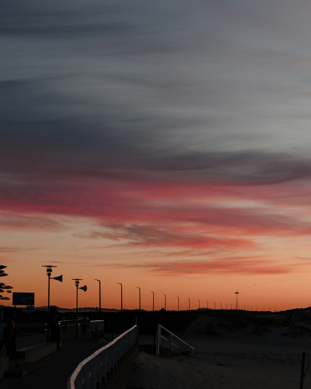 a person walking on a beach at sunset