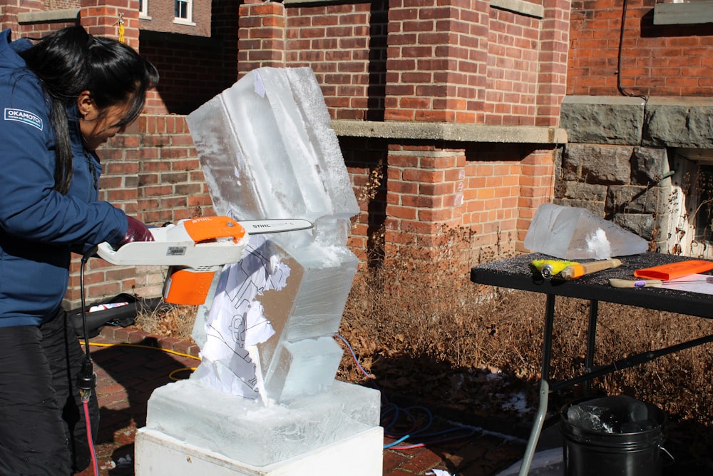 a woman is making a sculpture out of ice