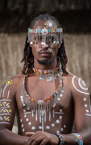 a man wearing a beaded headdress and beads
