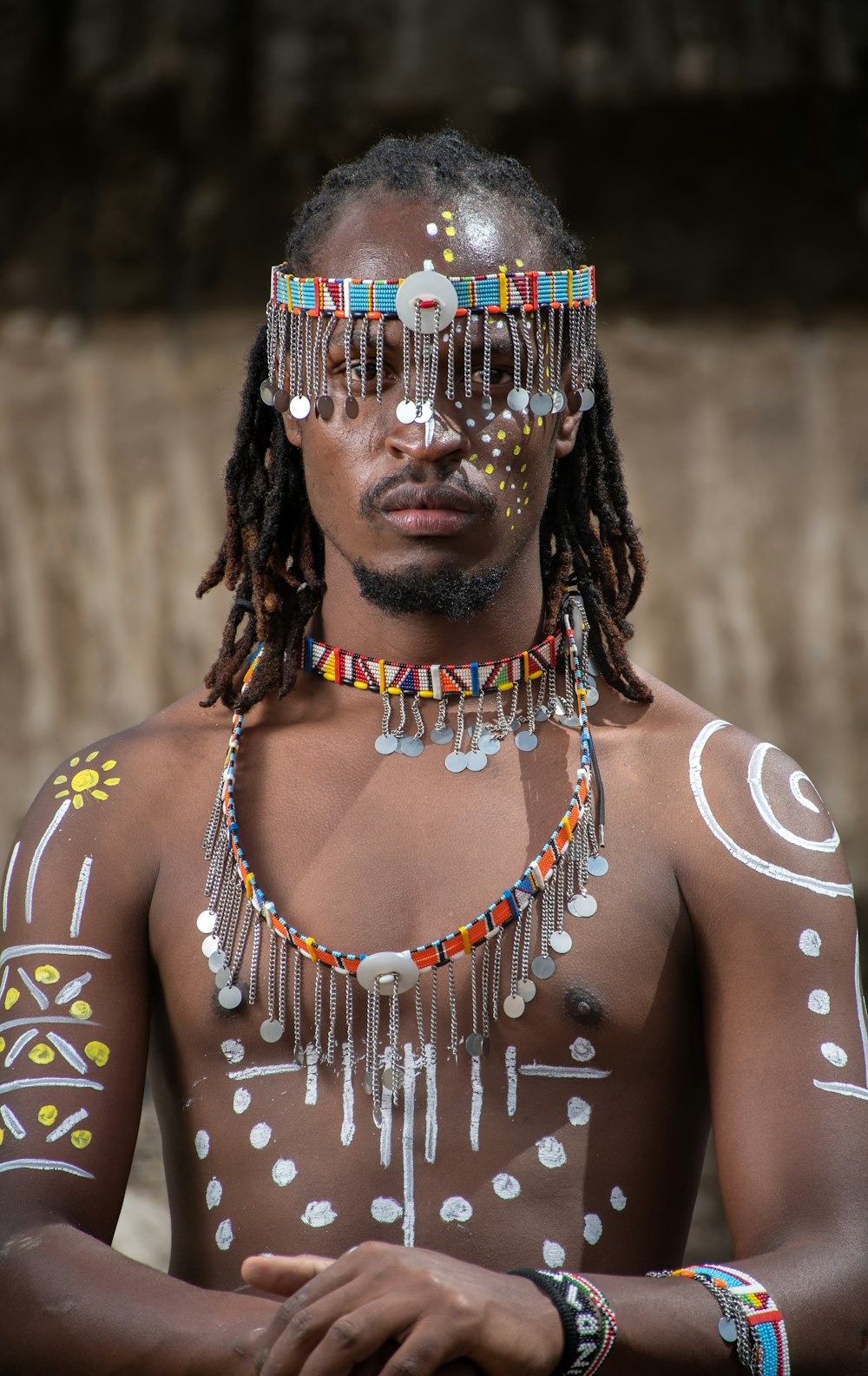 a man wearing a beaded headdress and beads