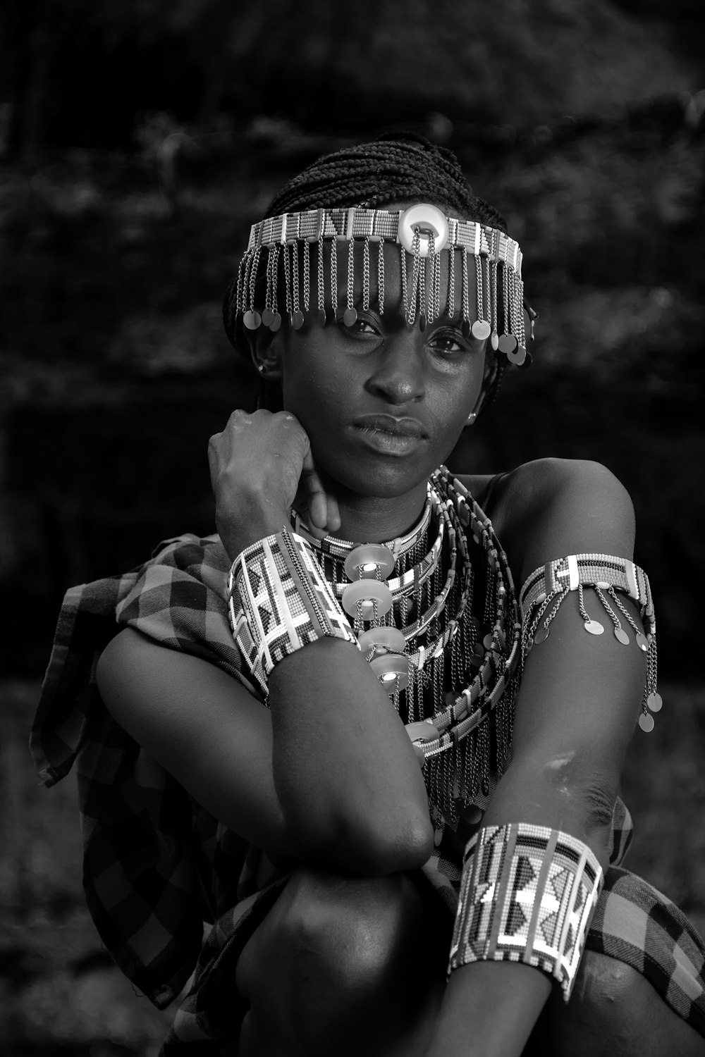 a woman in a headdress and bracelets