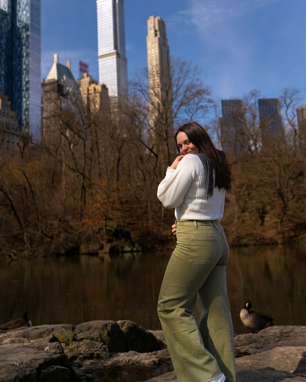 a woman standing on a rock near a body of water