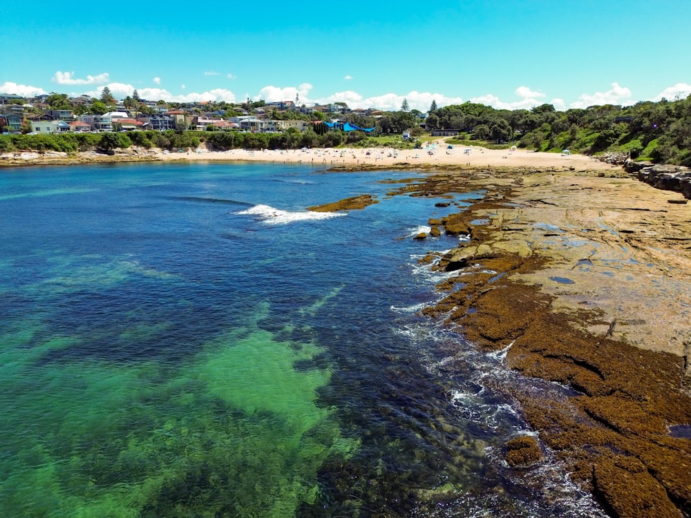 an aerial view of a beach with clear blue water