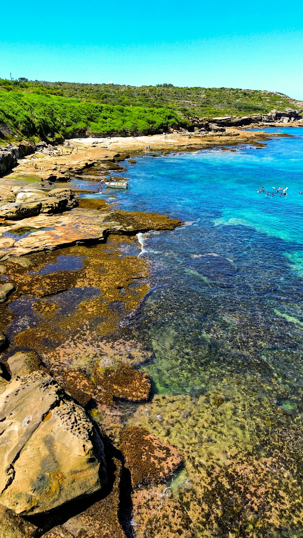 a body of water sitting next to a lush green hillside