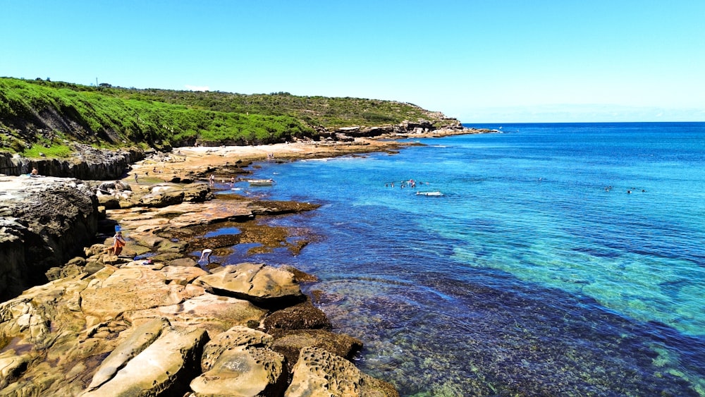 a view of a beach with people swimming in the water