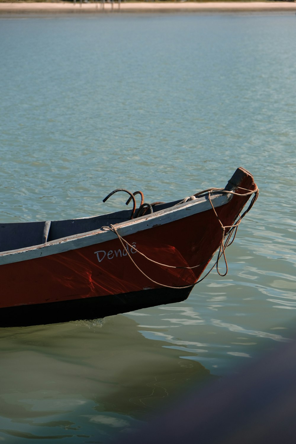 un bateau rouge et noir flottant au-dessus d’un plan d’eau