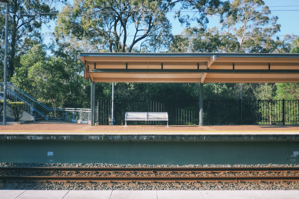 a train station with a bench on the platform