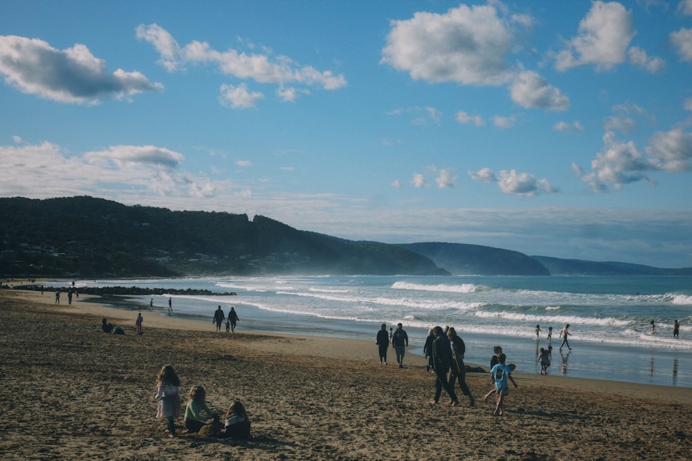 a group of people standing on top of a sandy beach