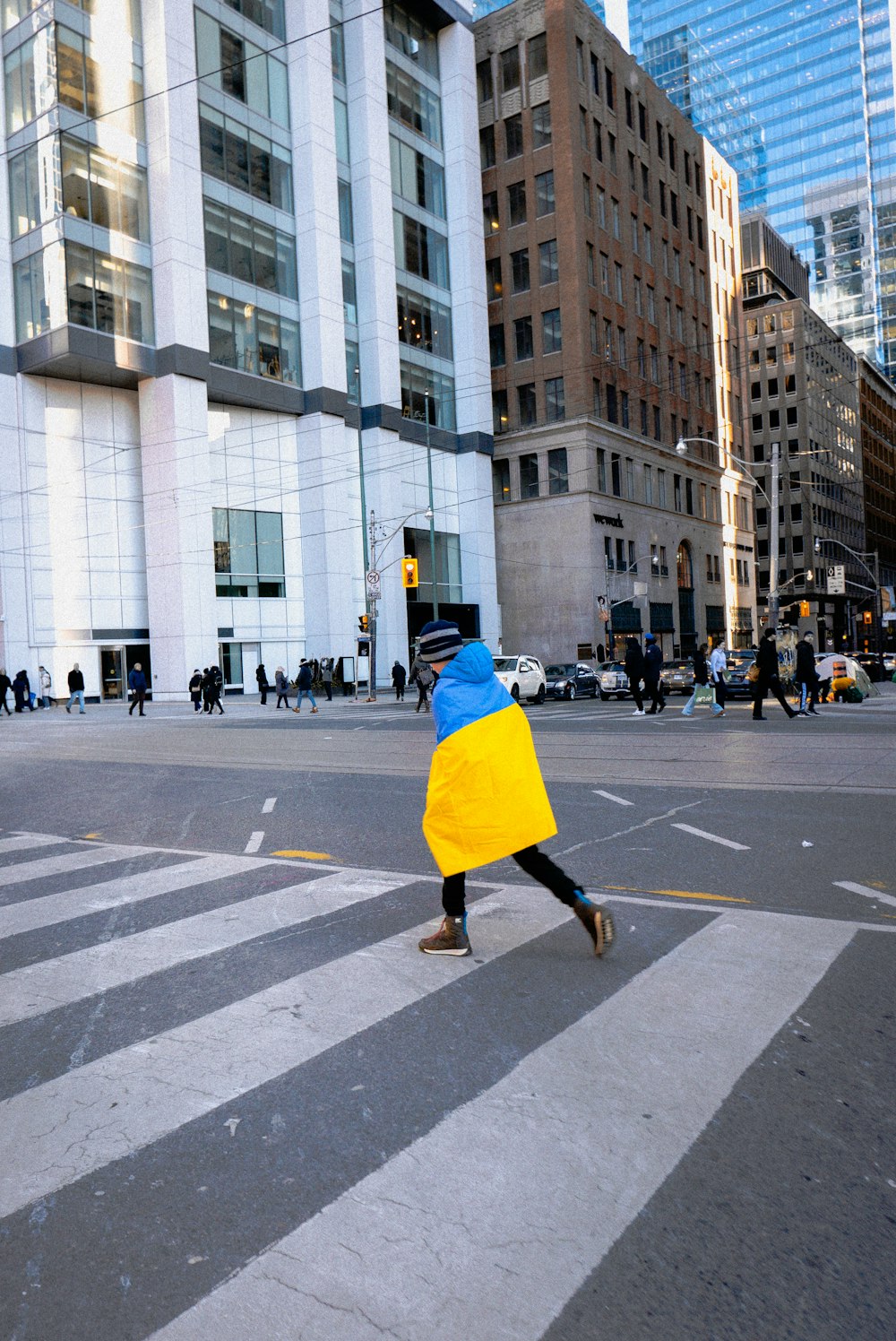 a person walking across a cross walk in a city