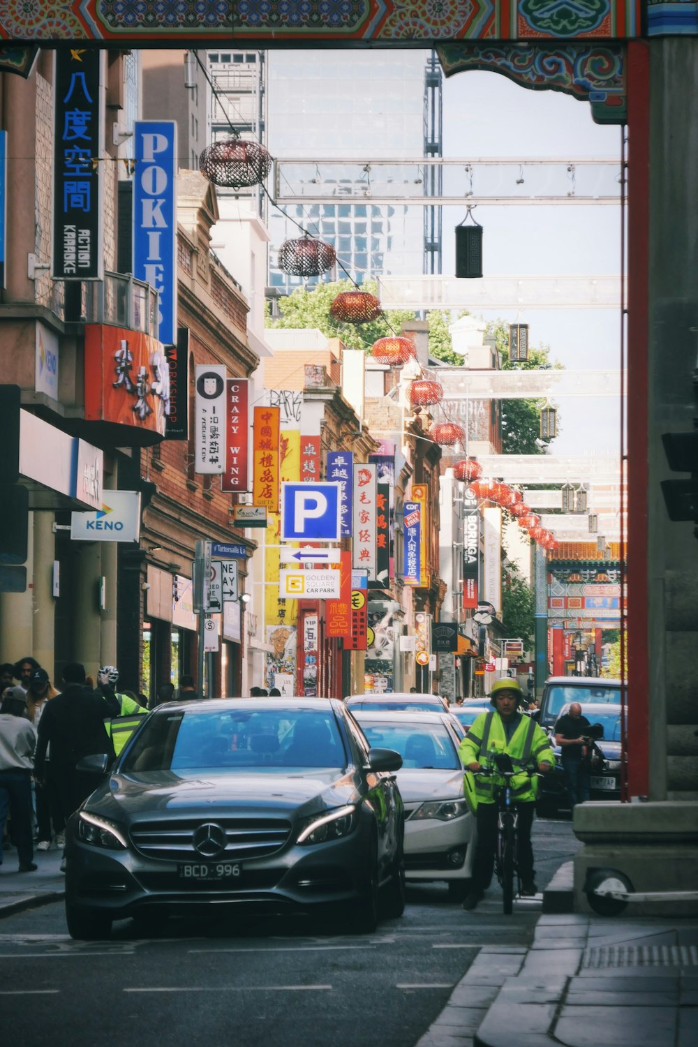 a city street with cars and people walking on the sidewalk