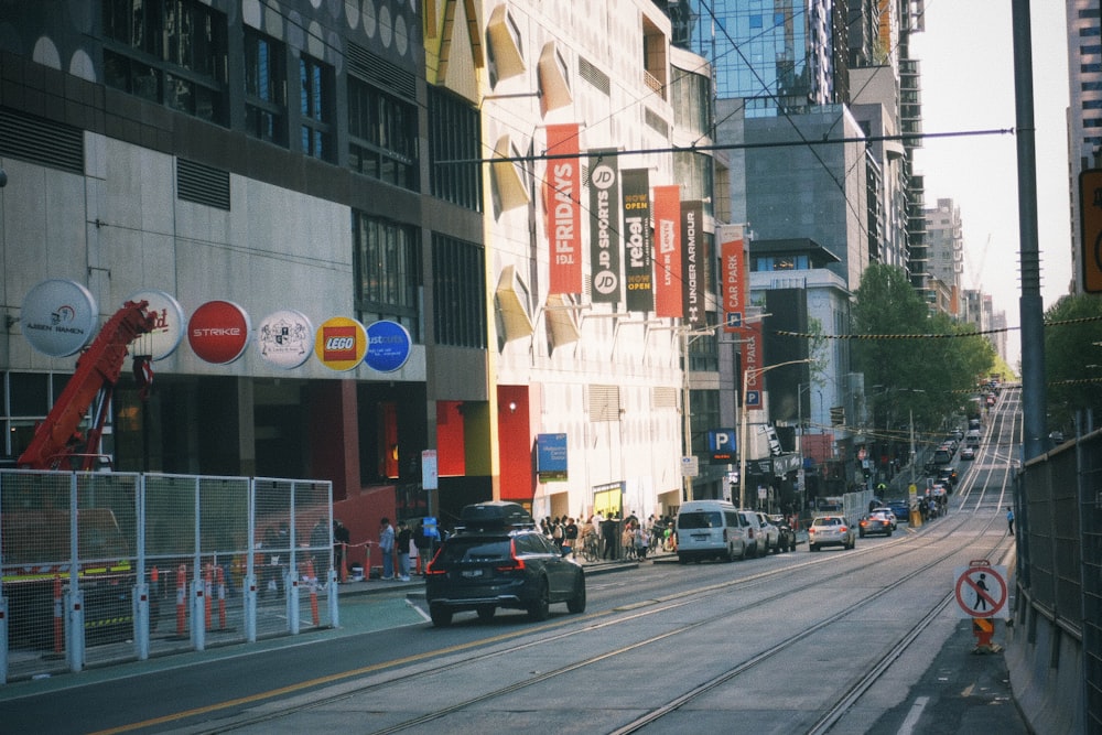 a city street filled with traffic next to tall buildings