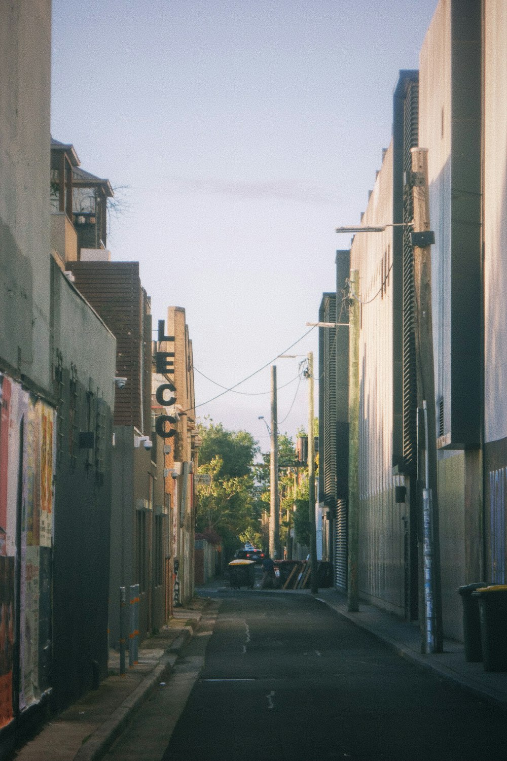 a narrow street with a traffic light on the side of it