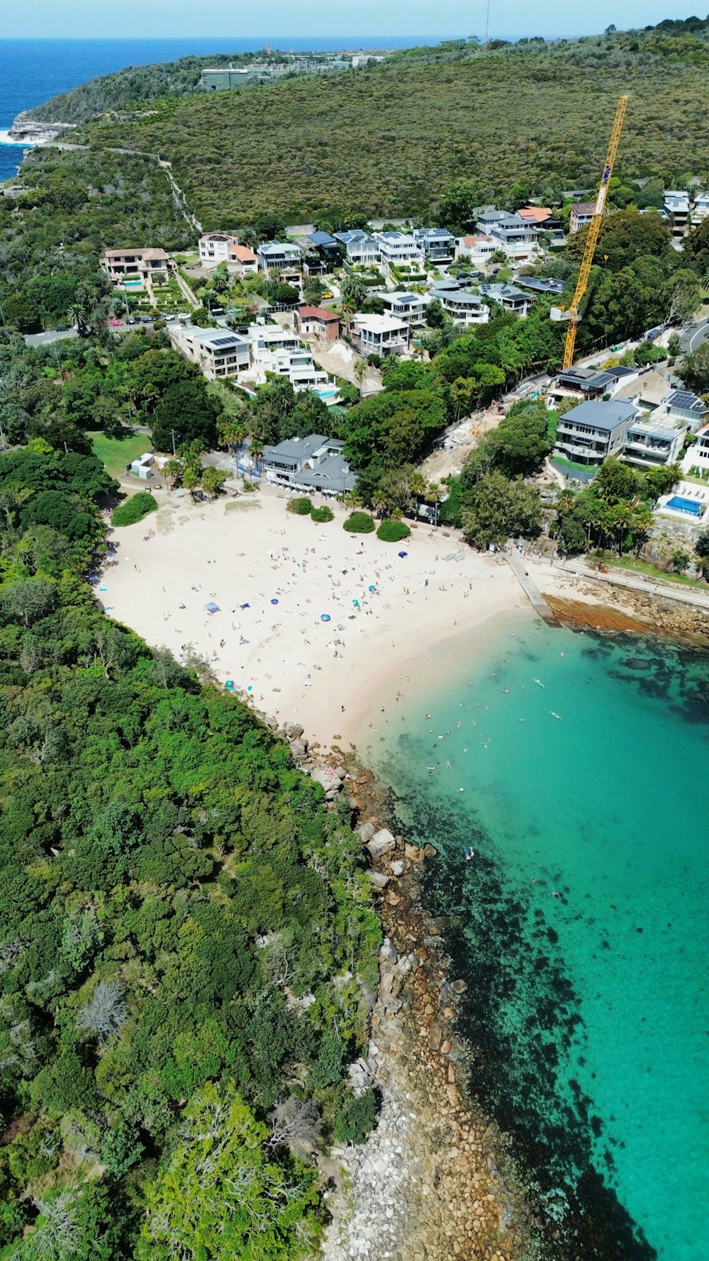 a bird's eye view of a beach with a crane in the background