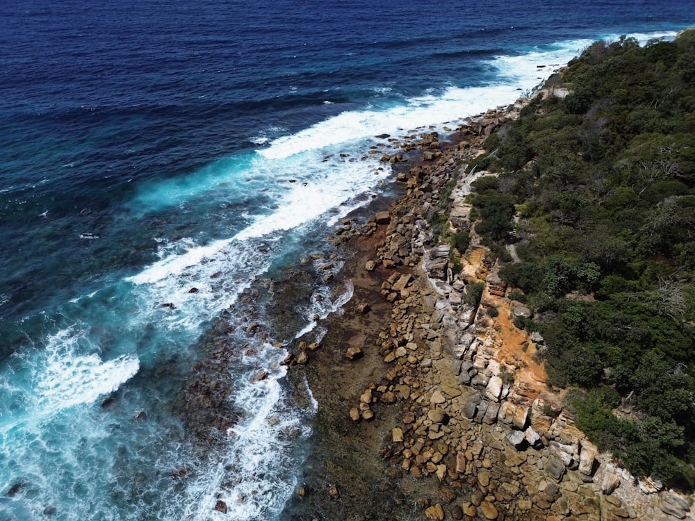 an aerial view of a rocky beach and ocean