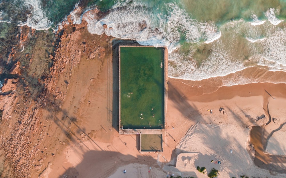 an aerial view of a beach with a swimming pool