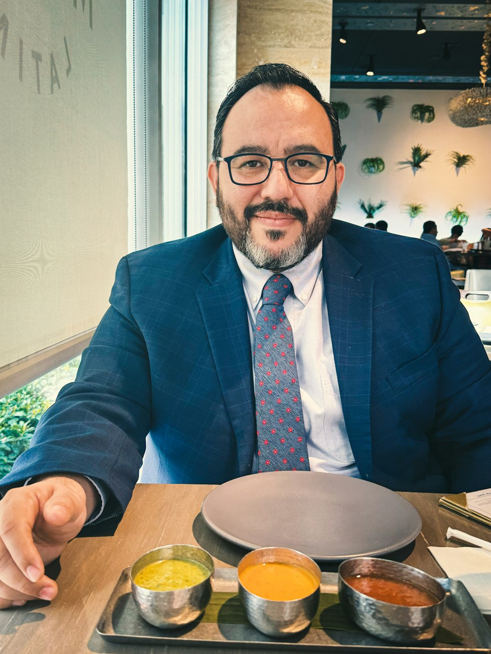 un homme assis à une table avec une assiette de nourriture