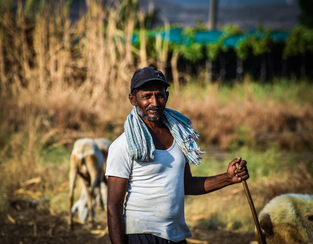 a man standing in a field with a stick in his hand