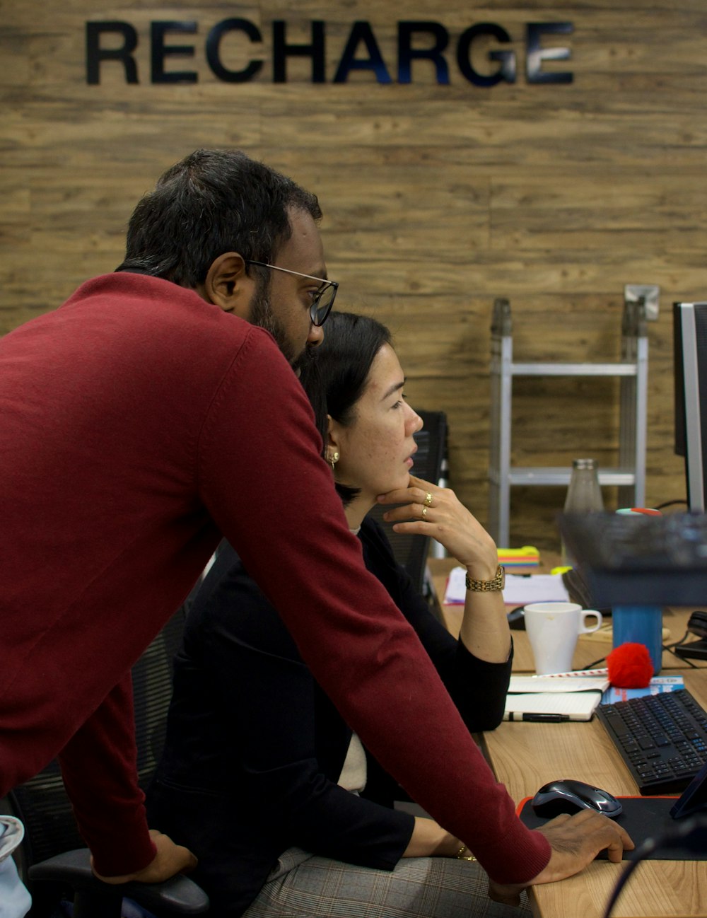 a man and a woman sitting in front of a computer