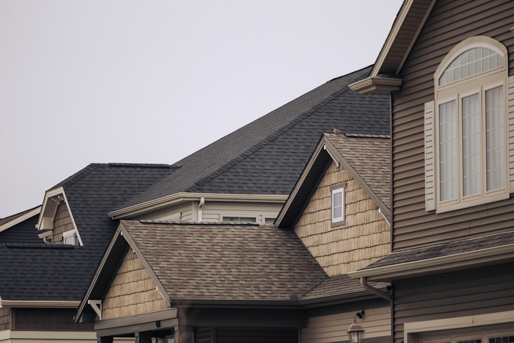 a row of houses with brown shingles and white windows