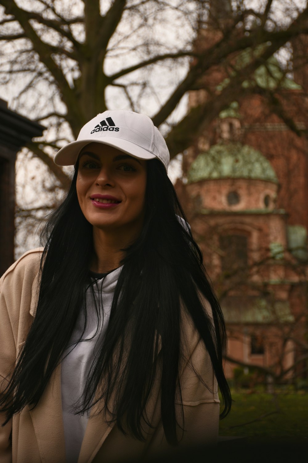 a woman with long black hair wearing a white hat