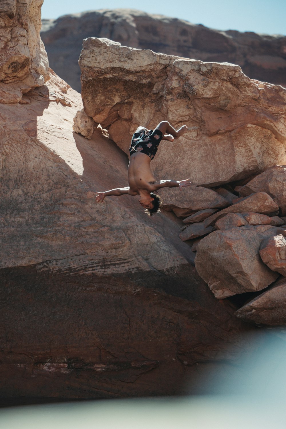 a man is climbing up a rock in the desert