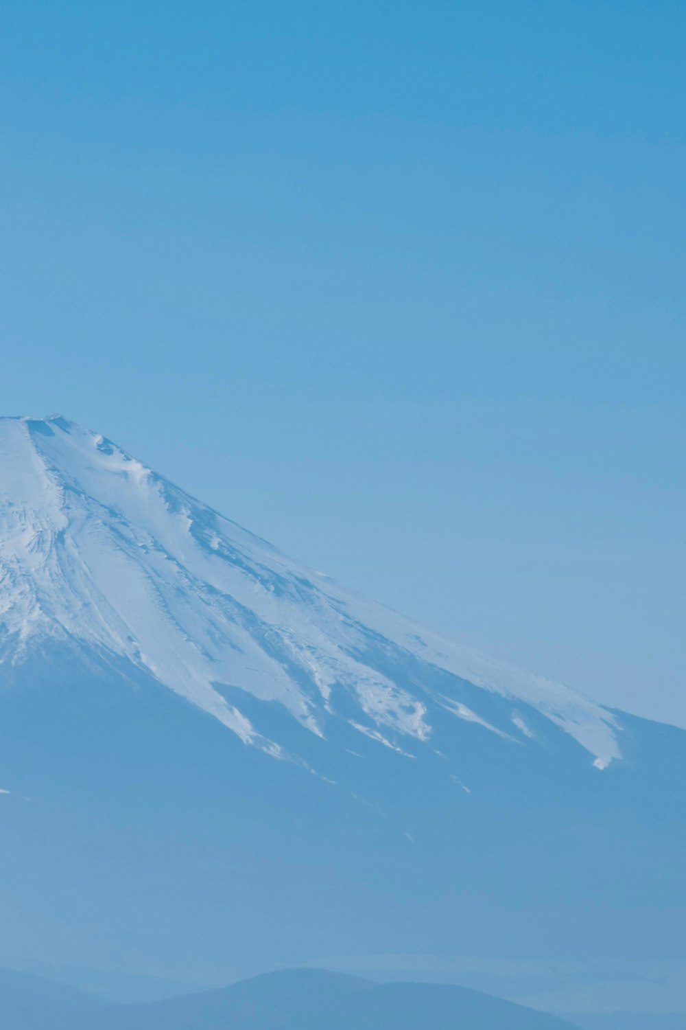 uma montanha coberta de neve ao longe sob um céu azul