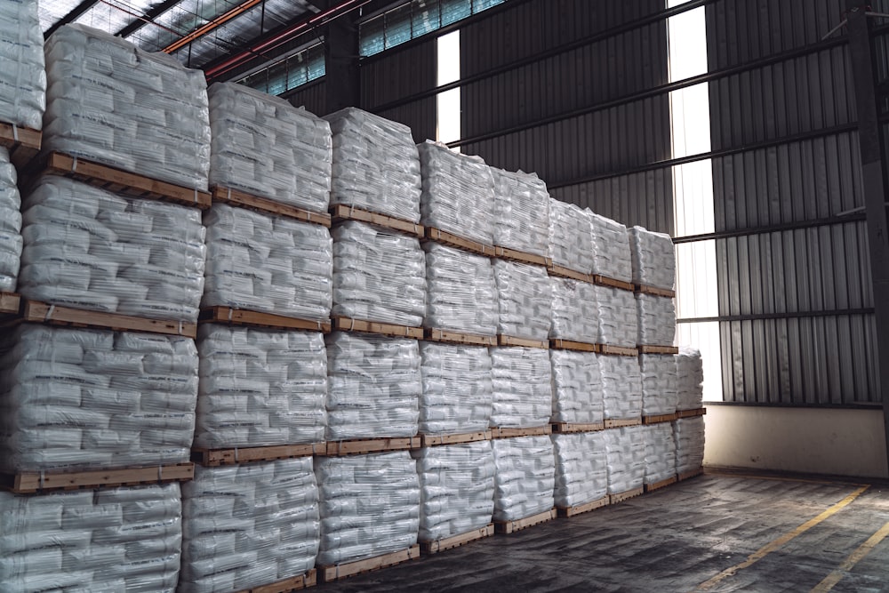 a warehouse filled with stacks of white bags