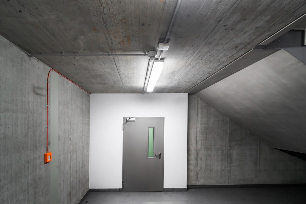 an empty room with a door and a green light