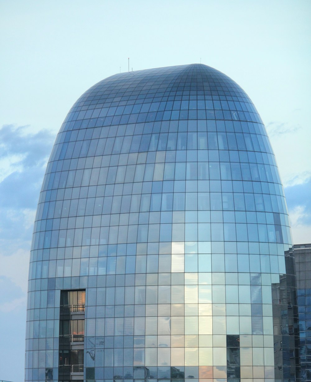 a large glass building with a sky background