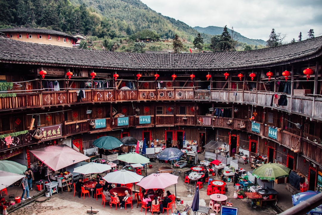 a group of people with umbrellas in a building, China