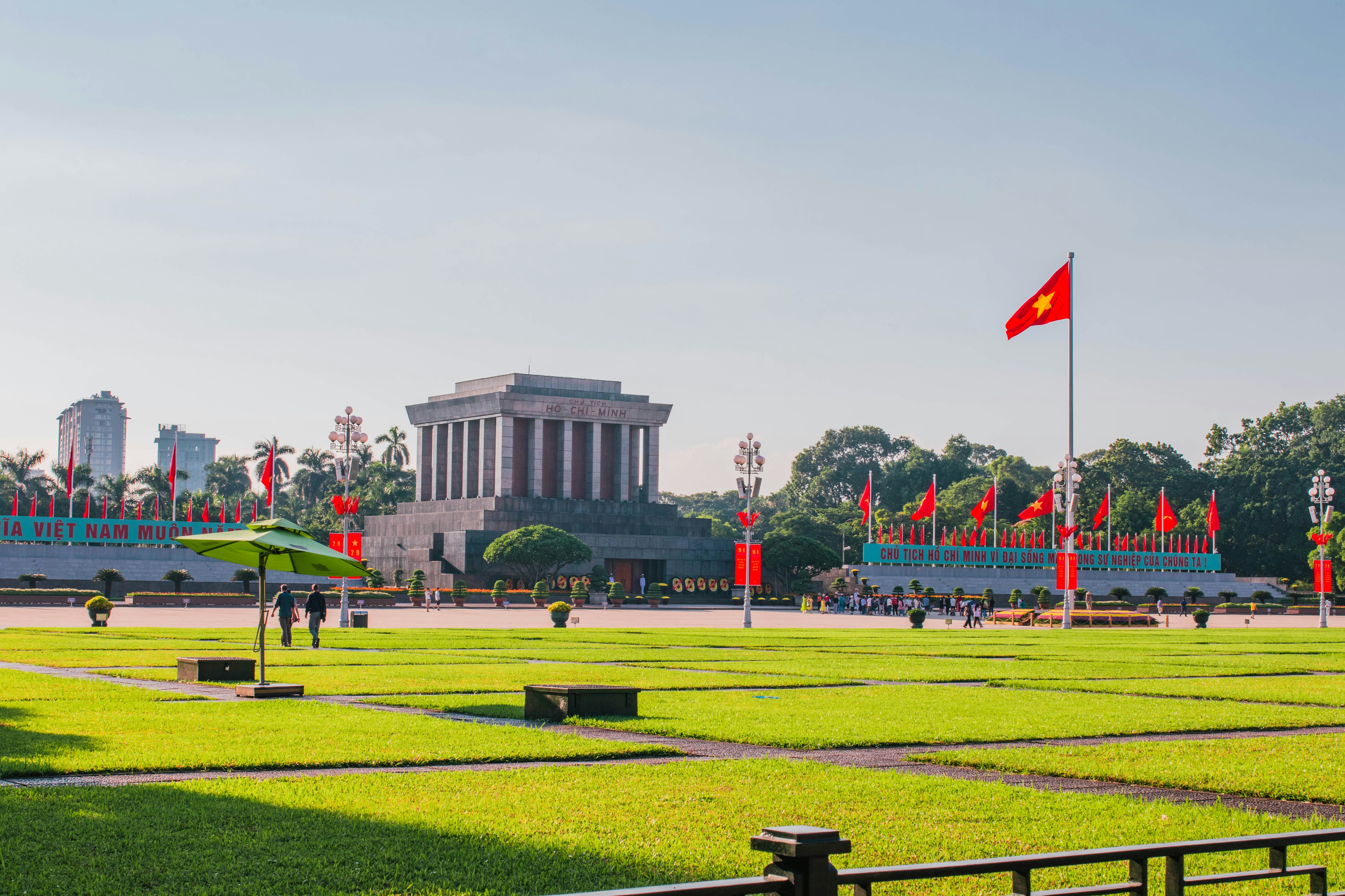 a large grassy field with a building in the background, Ho Chi Minh Mausoleum
