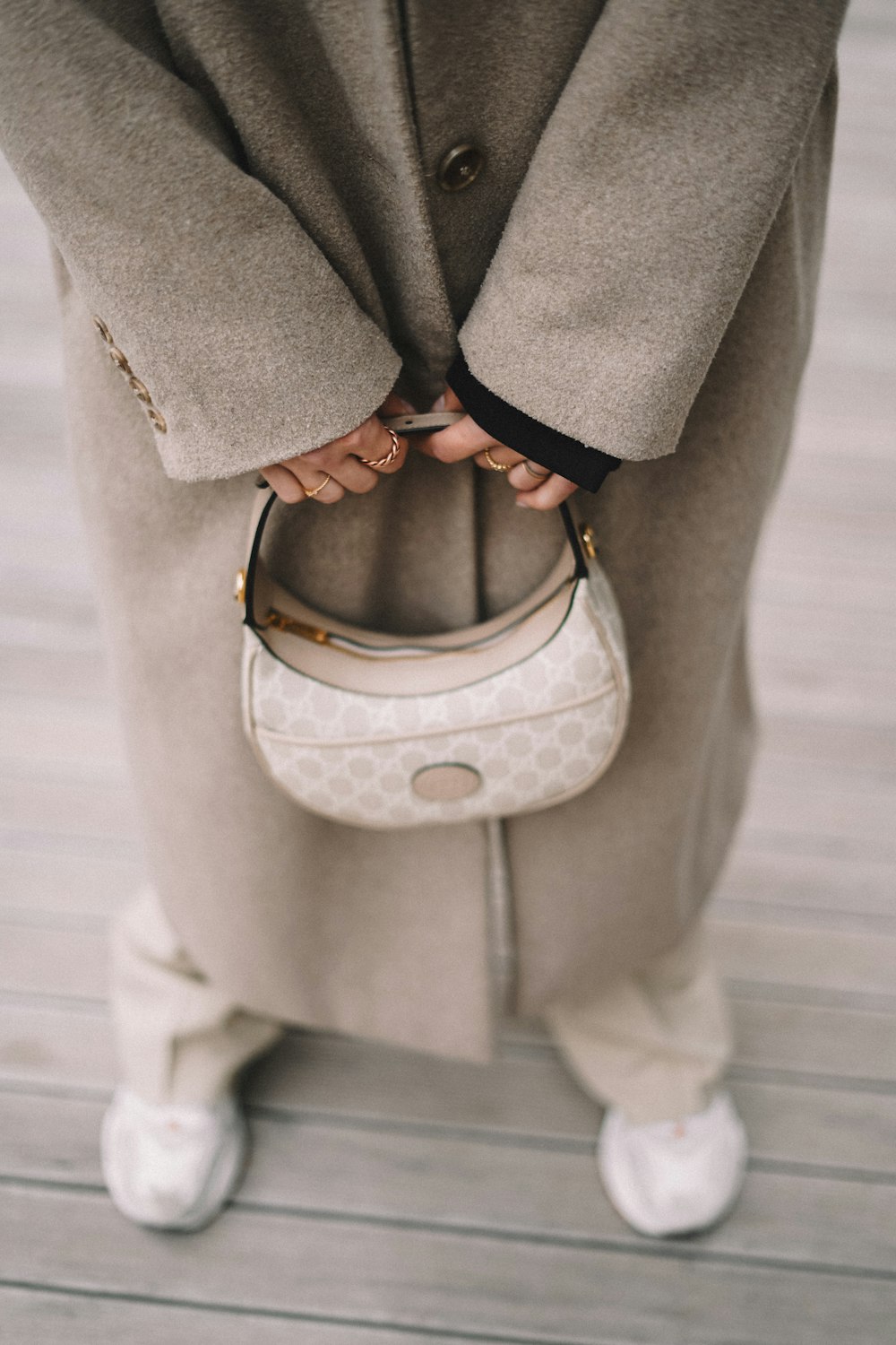 eine Frau, die eine weiße Handtasche in den Händen hält