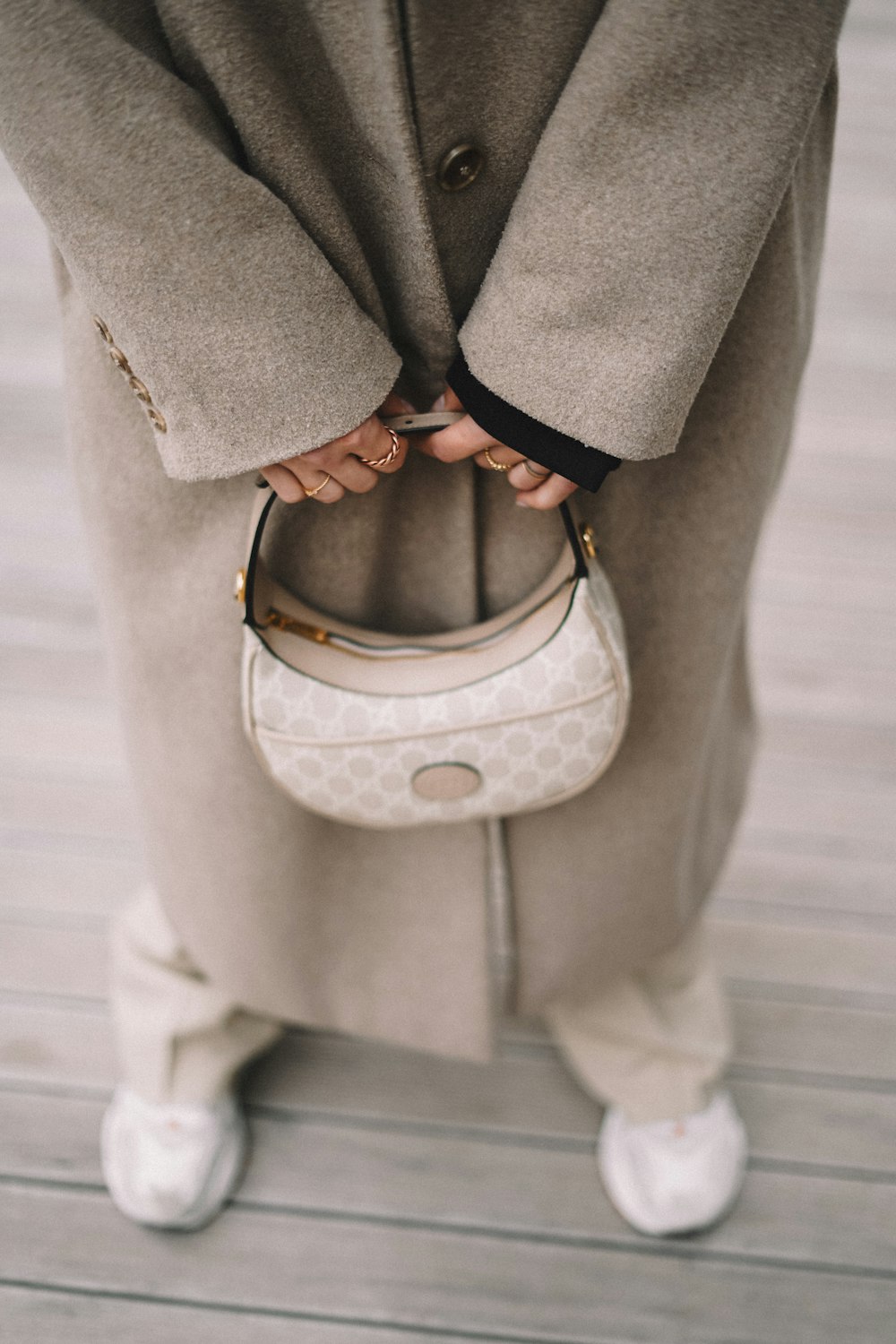 a woman holding a white purse in her hands