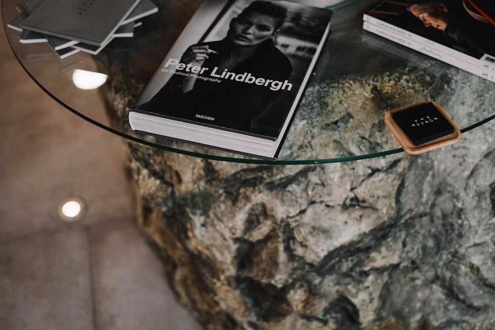 a glass table topped with books and a smart phone