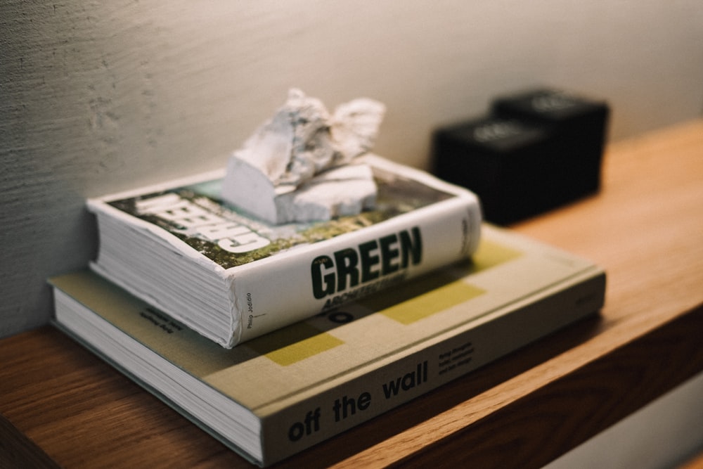 a stack of books sitting on top of a wooden table