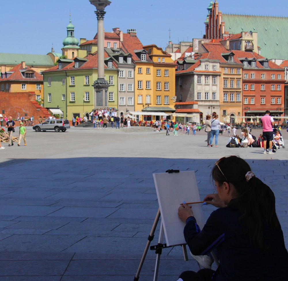 a young girl is painting in a square