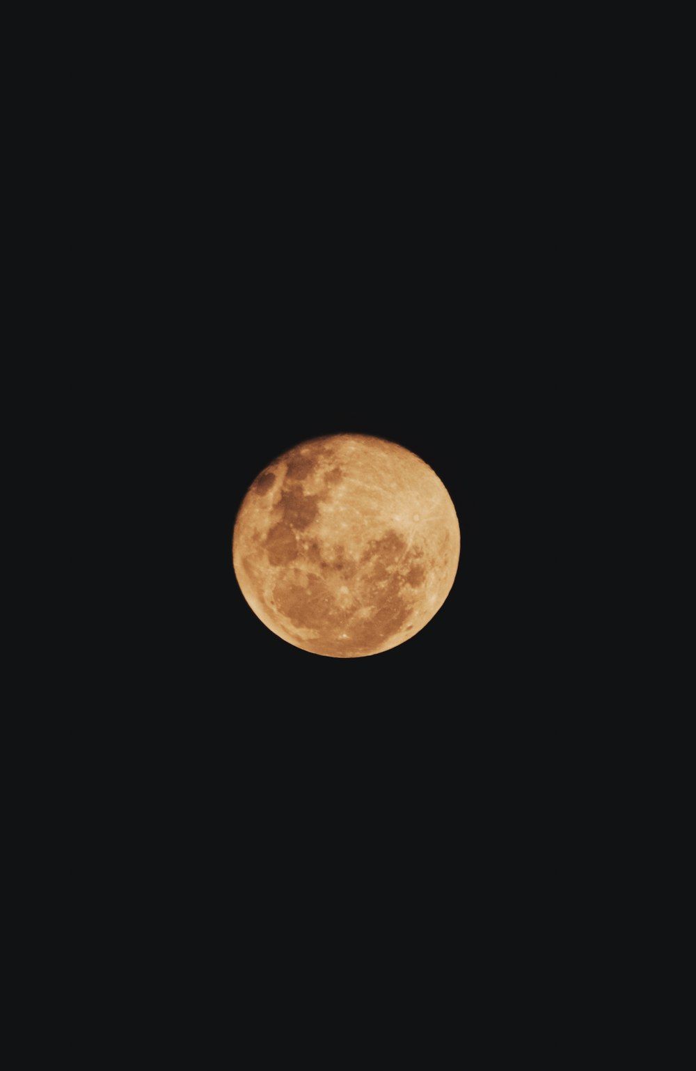 a full moon is seen in the dark sky