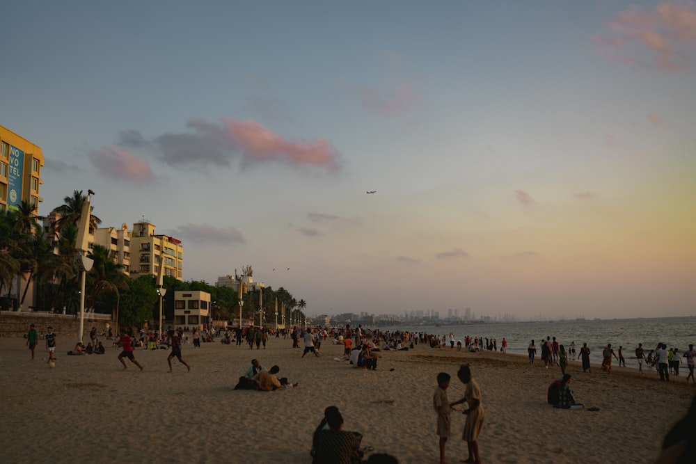 a group of people on a beach with buildings in the background