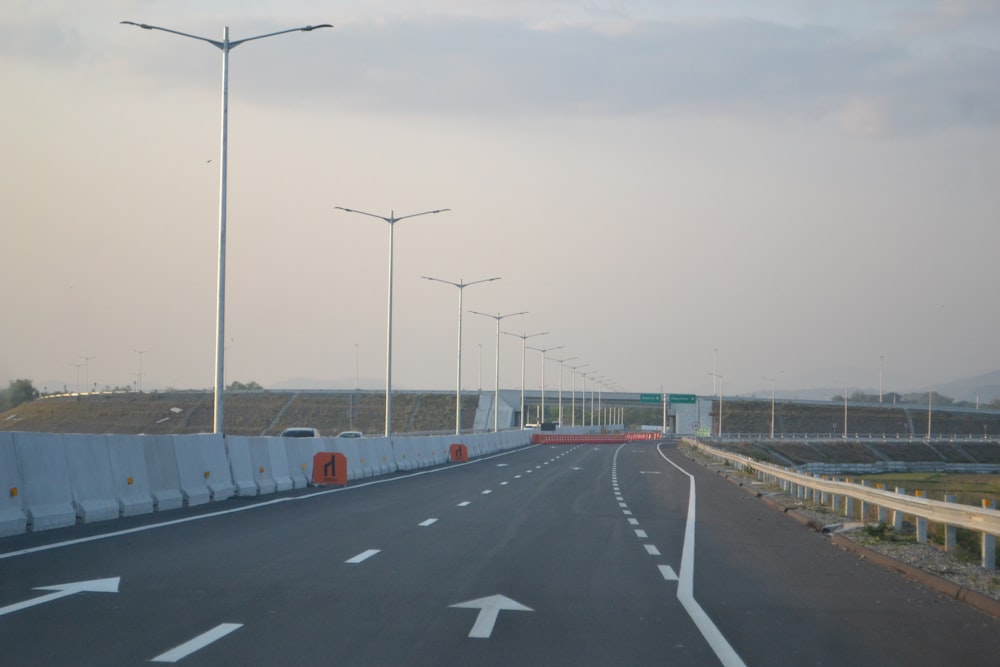 uma rodovia com um monte de postes de iluminação pública ao lado dela