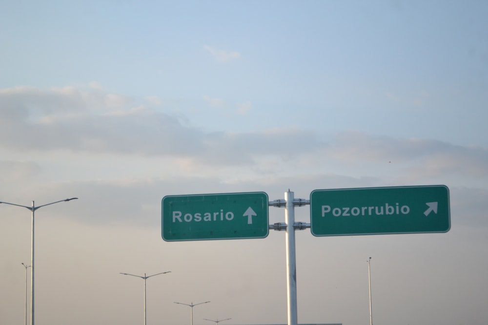 a couple of green street signs on a pole