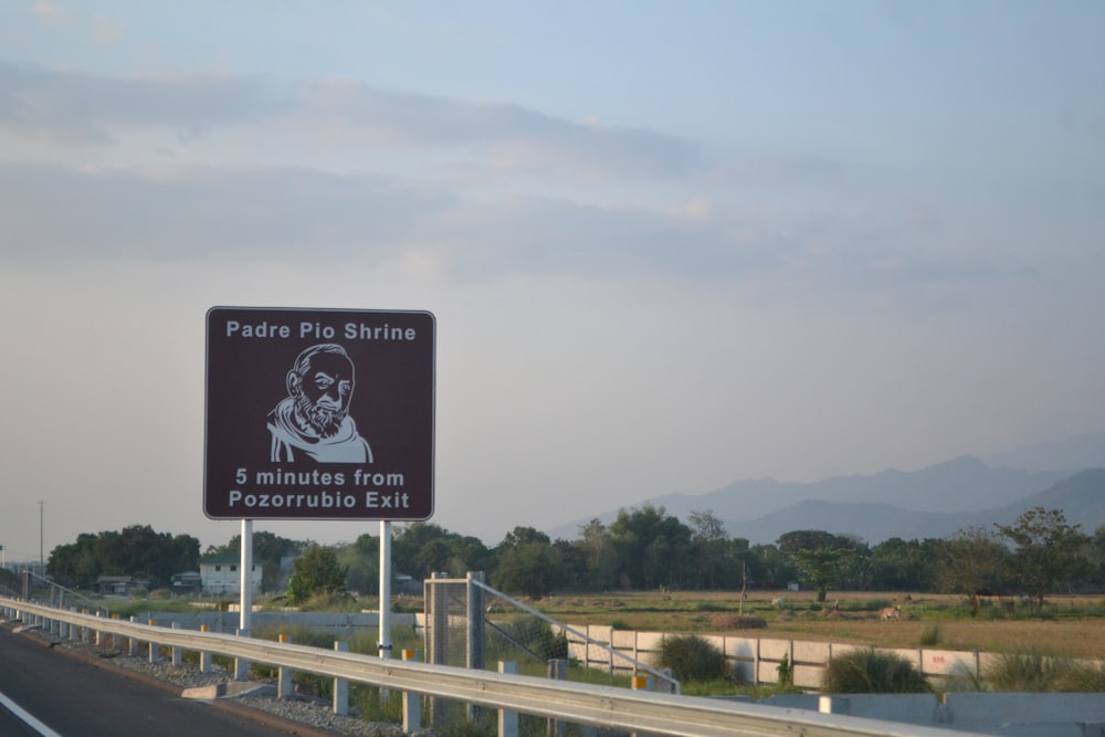 a street sign on a highway with mountains in the background