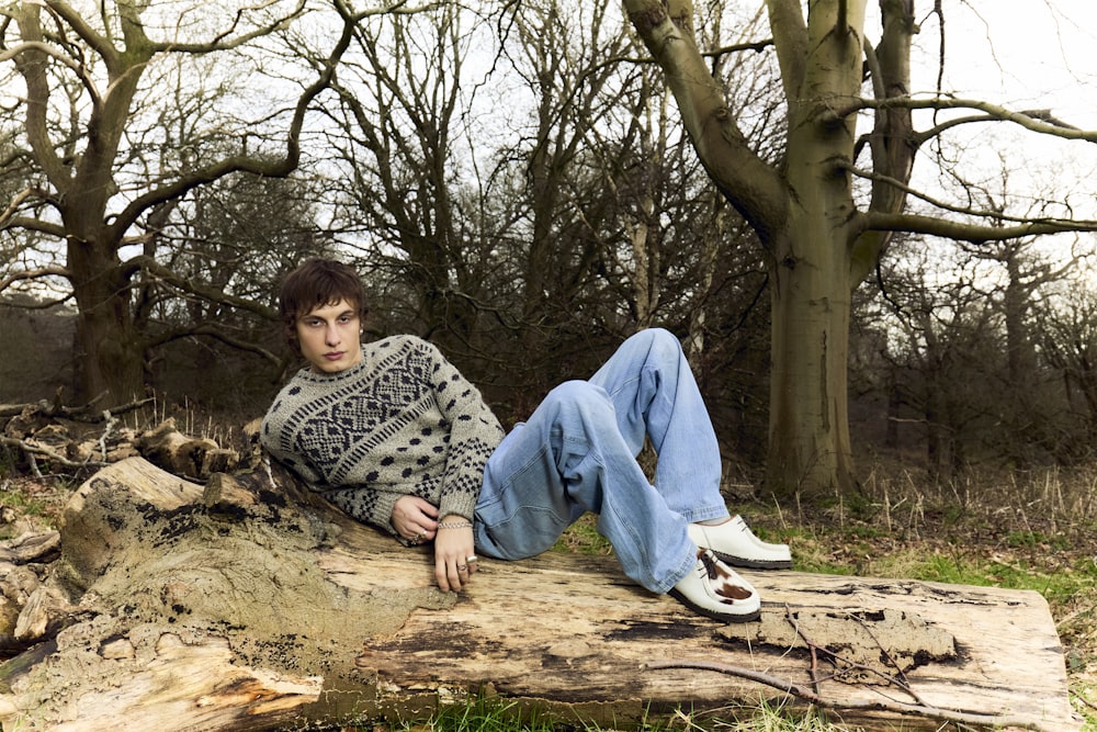 a man sitting on a log in the woods