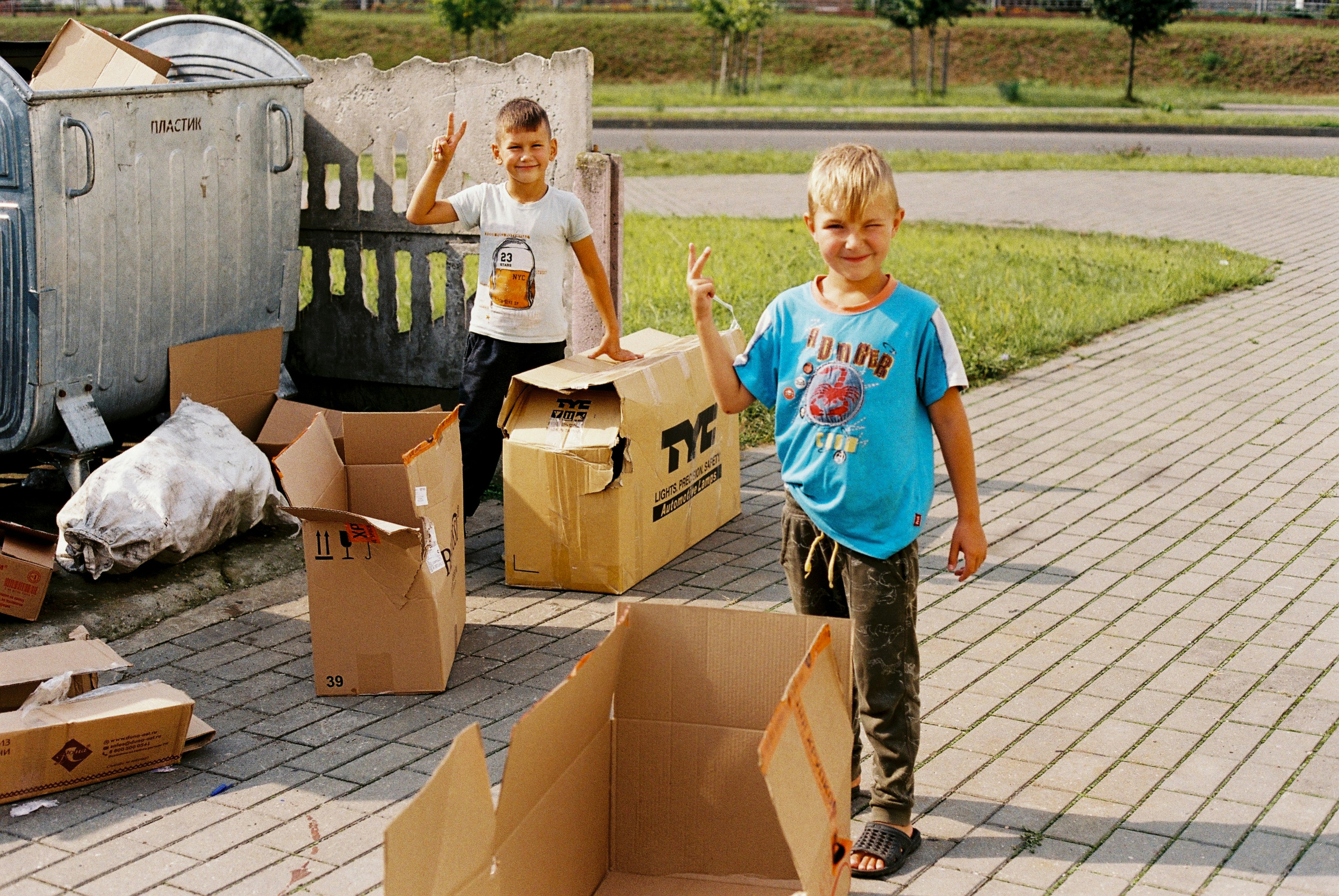 a couple of kids standing next to boxes