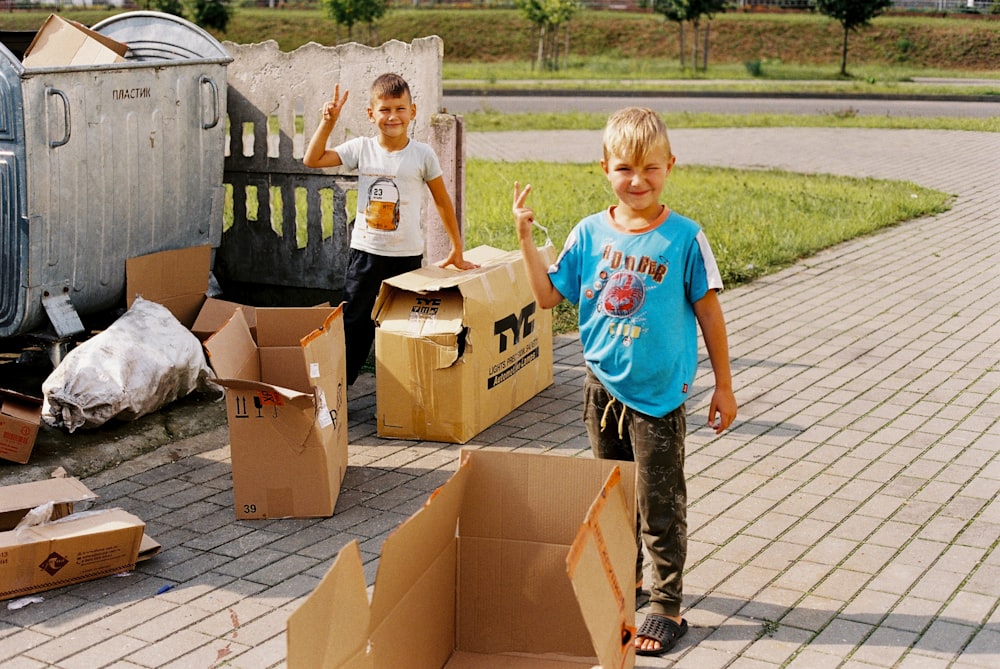 a couple of kids standing next to boxes